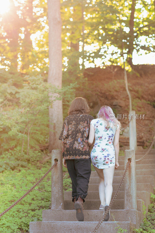 一对情侣在浪漫的爱情中一起爬上老公园的楼梯