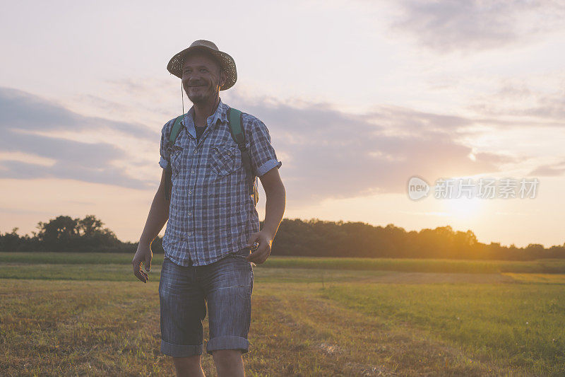 成年男子冒险家徒步在美丽的夏日日落大自然