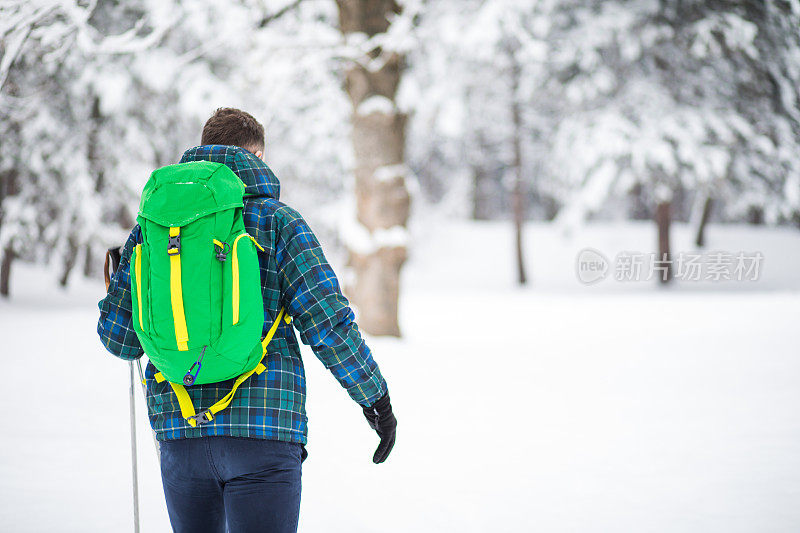 年轻人后视图独自行走雪山的旅行者。