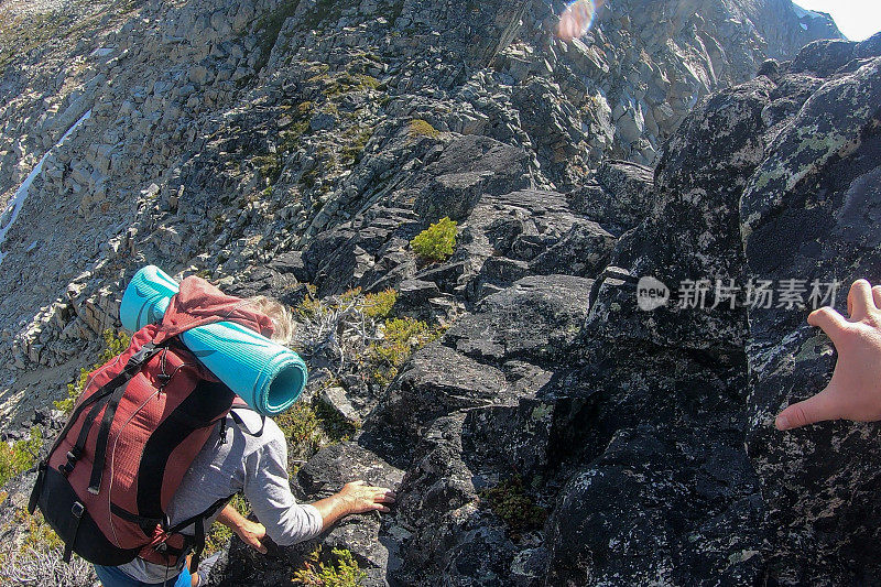 日出时分，男性徒步旅行者穿过山腰