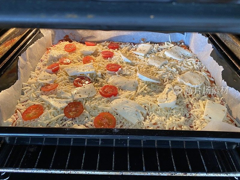 新鲜披萨在烤箱准备烘烤