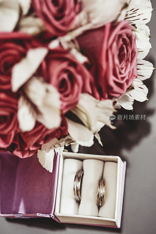 盒子里有一对结婚戒指和新娘的花束