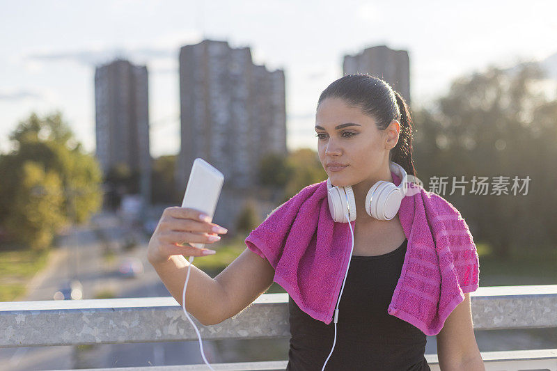 女孩戴着耳机用智能手机