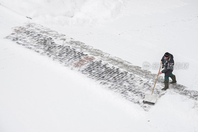 穿制服的工人在城市里清除积雪