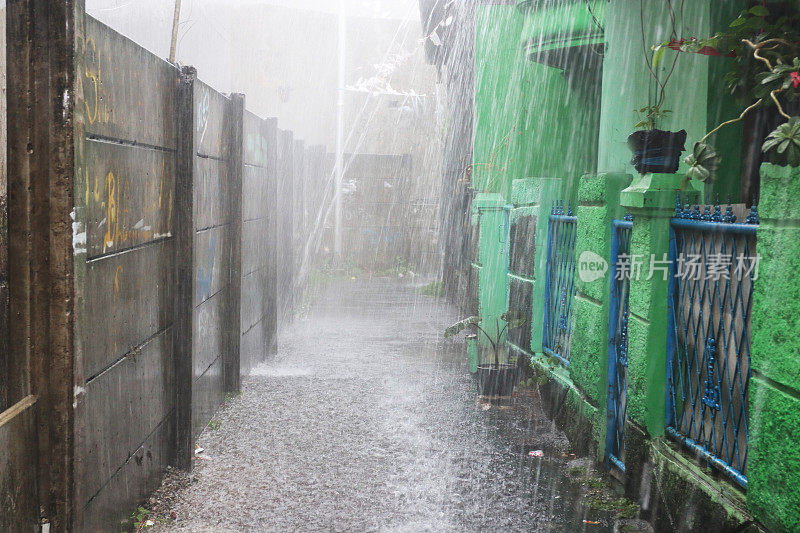 一个小女孩在倾盆大雨中带着雨伞。