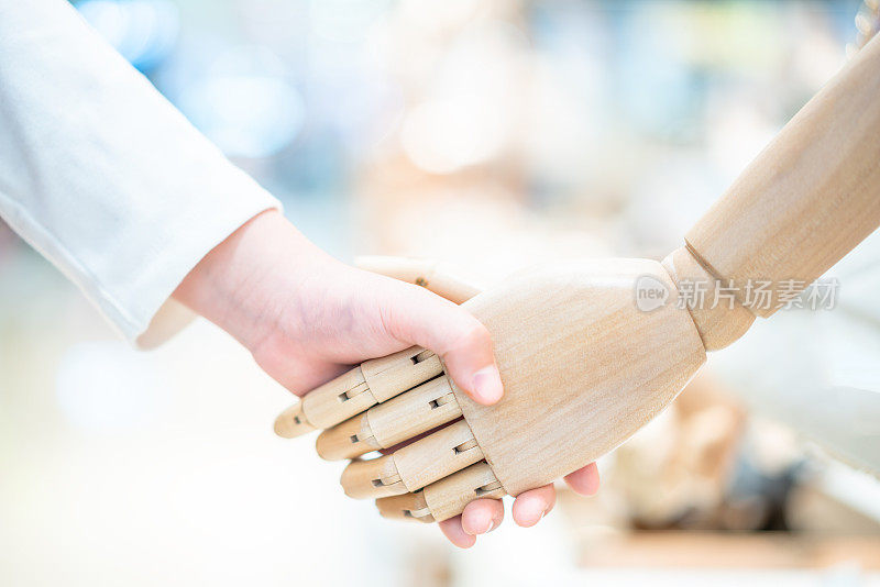 孩子的手握着机器人的手