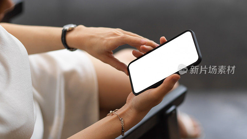 俯视图的女性使用智能手机包括剪切路径屏幕在她的手中