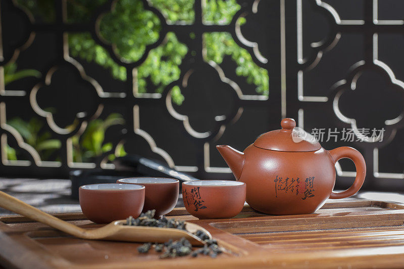 窗花旁桌上的中国茶壶和茶杯富有禅意