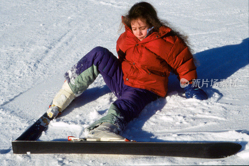 一个小孩滑雪时摔倒了