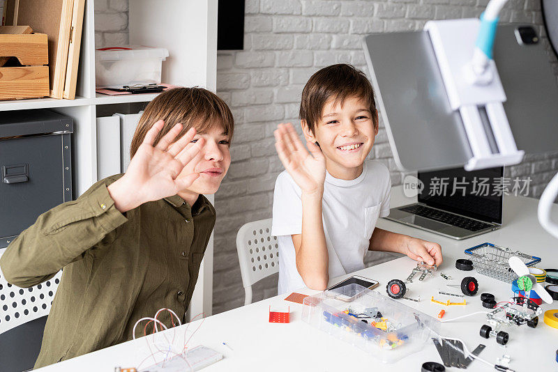 小男孩们在用数字平板电脑上在线上课，制造机器人汽车