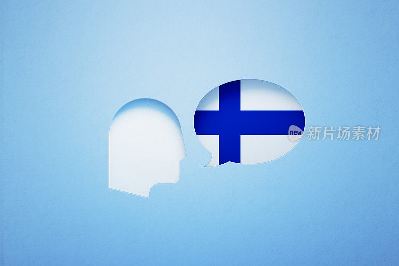 芬兰语学习和说话的概念-讲话气泡形状纹理与芬兰国旗坐在旁边的一个切割出的人的头在蓝色背景