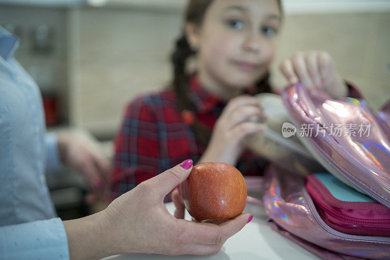 妈妈和她的女儿在为学校准备午餐