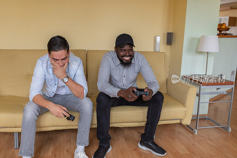 一个快乐的留着胡子的非洲人正在和他的朋友玩电子游戏。