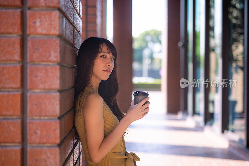 日本女子倚在城市红砖墙上的肖像