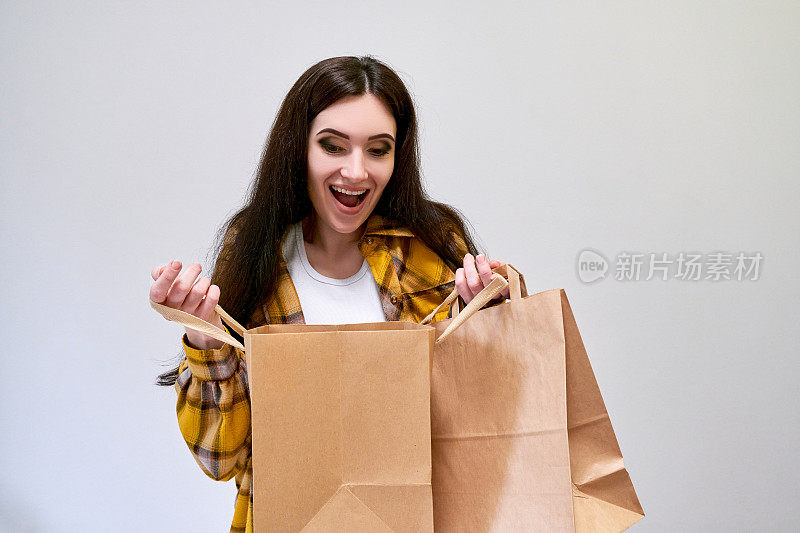 “黑色星期五”的概念。惊讶的女人拿着购物袋，喜欢购物