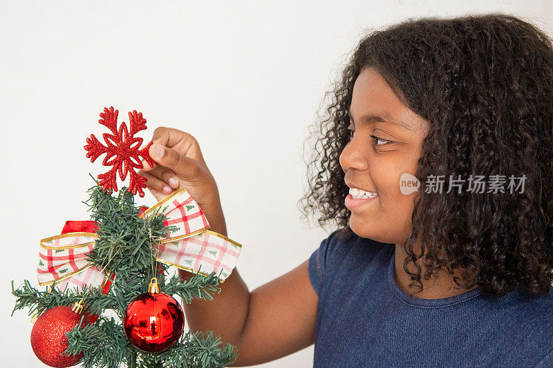 黑人女孩骑在圣诞树上