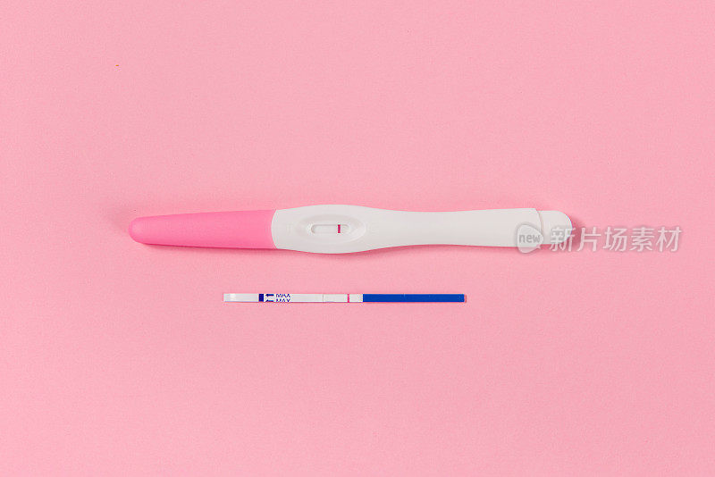 阴性妊娠检测试剂盒孤立在粉红色背景。