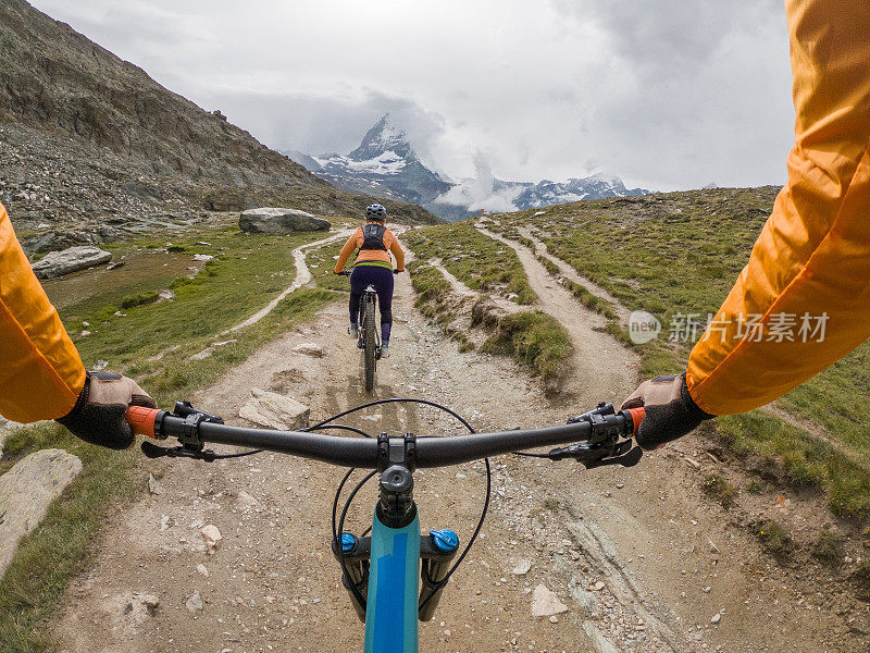 在瑞士阿尔卑斯山的土路上骑山地自行车的人