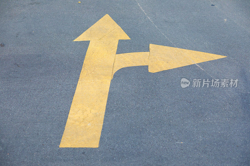 街道上有两个方向的黄色箭头标志