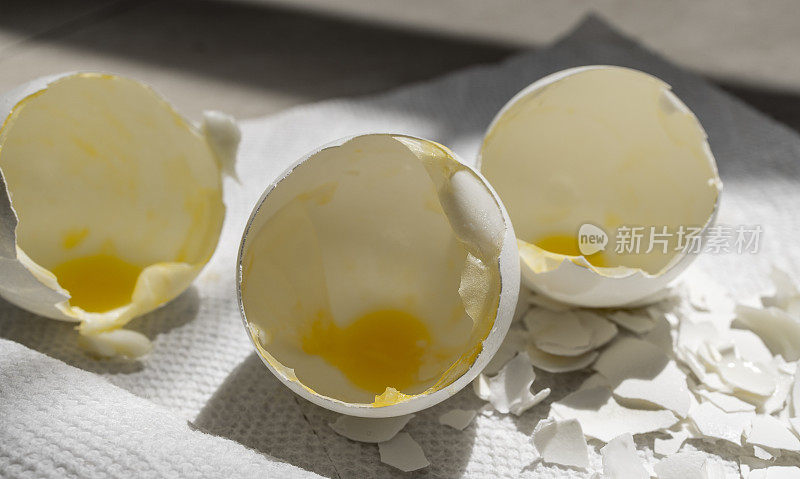 蛋壳破裂，蛋黄在白色餐巾上，近照。