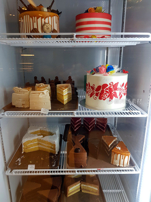 混合巧克力蛋糕和水果蛋糕的甜点放在冰箱的陈列柜里。