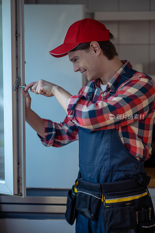 兴高采烈的修理工正在安装厨房的窗户
