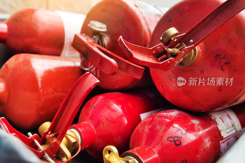 许多红色的灭火器堆在一起。灭火设备。用于灭火的灭火器的分发。