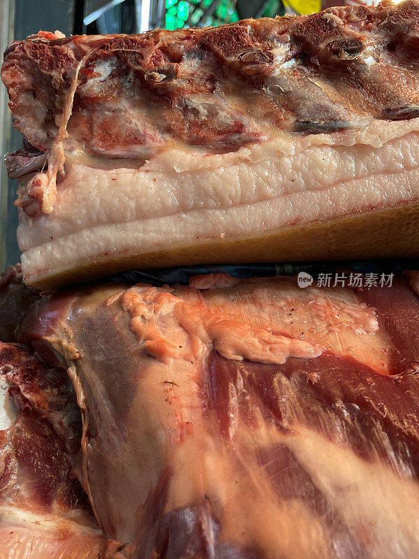 肉铺展示出售的五花肉的特写图像，廉价的肥肉，重点在前景