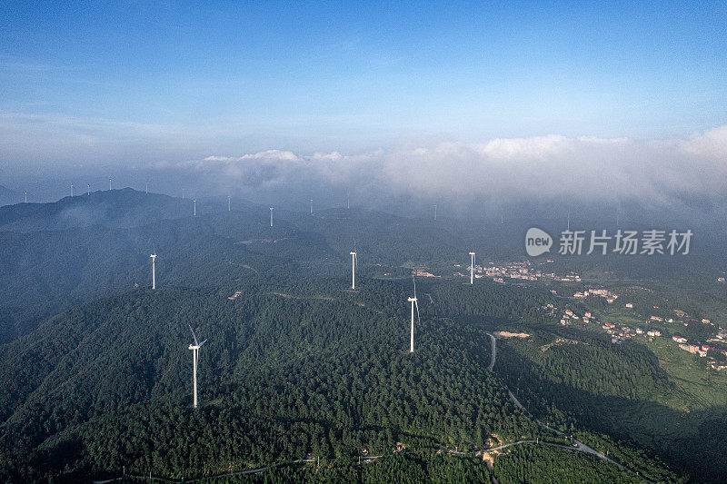 风力涡轮机和阳光山上的村庄