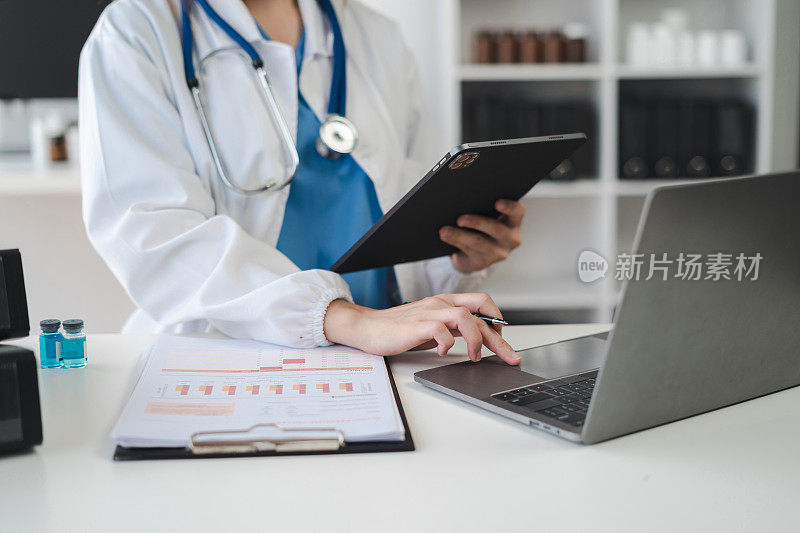 医生工作在数字平板电脑保健医生技术平板电脑使用电脑在一个现代化的办公室在办公桌前。