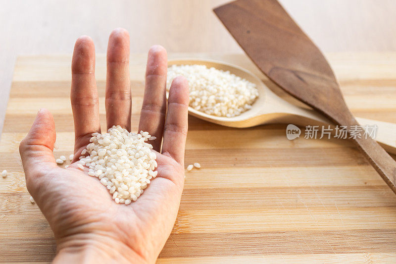 手里拿着煮饭用的生白米