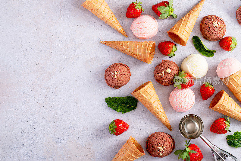 框架有冰淇淋，蛋筒有巧克力，香草和草莓的味道，平躺在浅灰色的桌子上，俯视图
