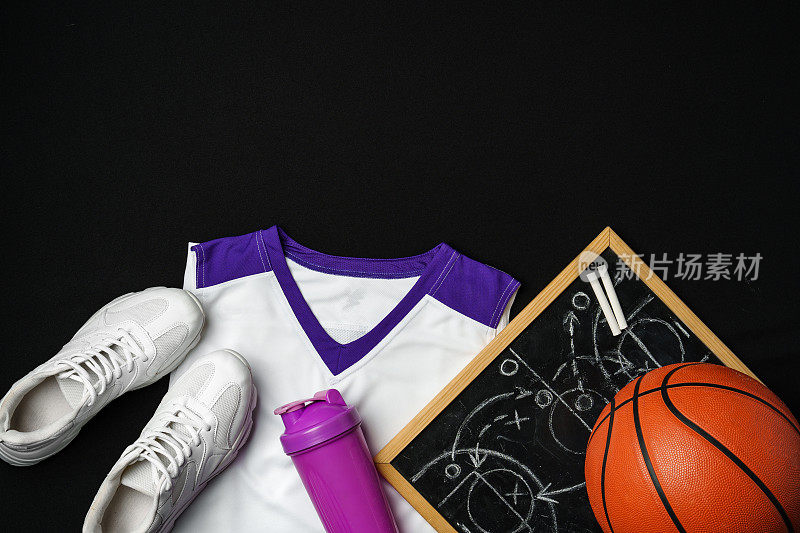 篮球装备，包括运动鞋，球，并发挥战略板上的黑色背景