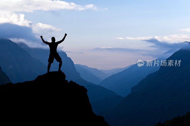 男人登山成功的剪影在山上