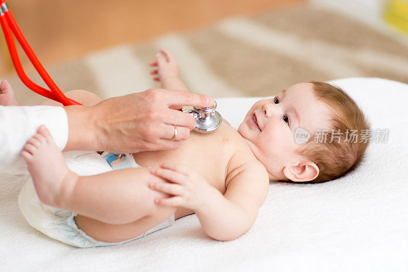 儿科医生检查三个月的男婴。医生使用听诊器