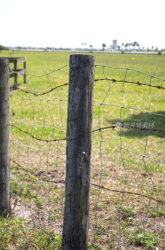 牧场周围的木栅栏杆和带刺铁丝