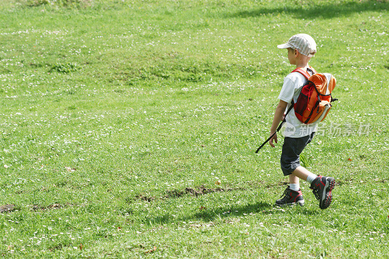年轻的徒步旅行者在草地上下山