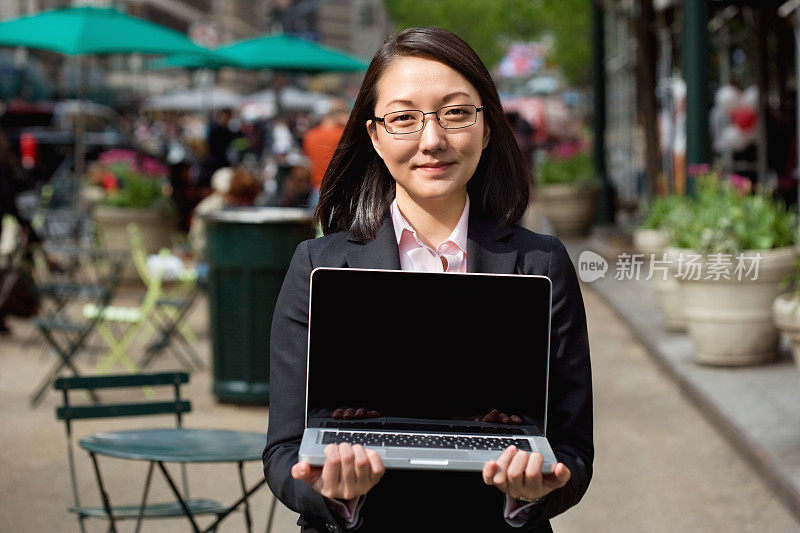 年轻的女商人介绍一台笔记本电脑