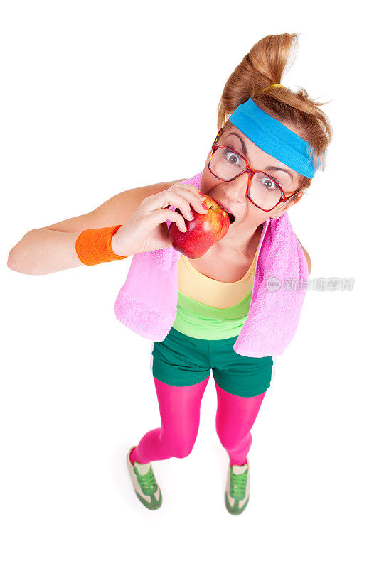 饥饿的书呆子健身女孩戴着眼镜吃苹果