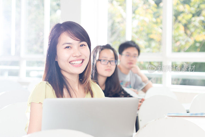 亚洲女孩在教室里用笔记本学习