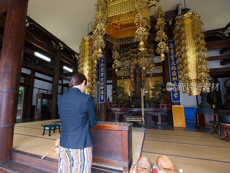 年轻女子在寺庙里祈祷