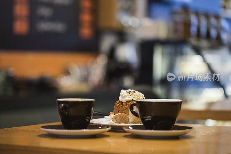 咖啡杯和松饼在咖啡馆的桌子上