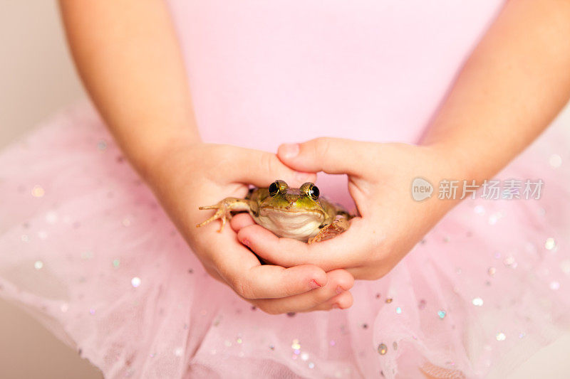 穿着粉色短裙的小公主抱着一只青蛙