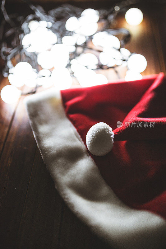 圣诞帽在木板上与圣诞灯