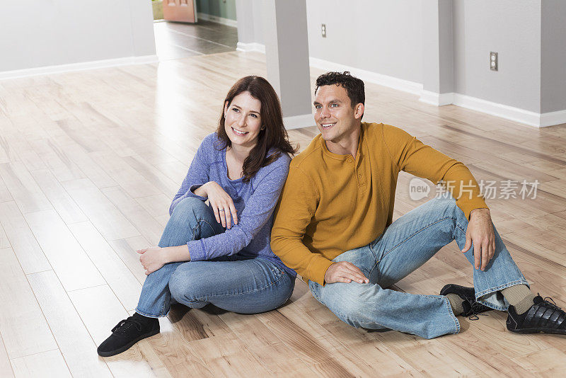 年轻夫妇坐在地板上