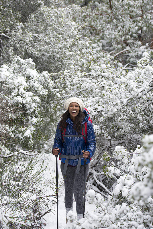 女人在下雪的天气徒步旅行。