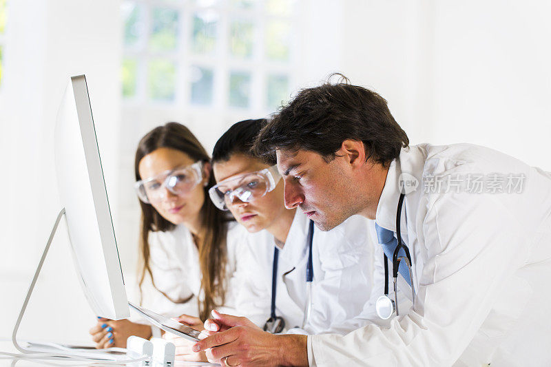 两个年轻医生在看电脑显示器上的东西