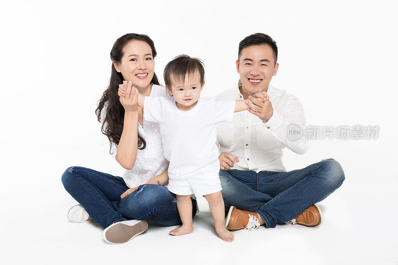 幸福的亚洲年轻家庭在白色背景下摆姿势