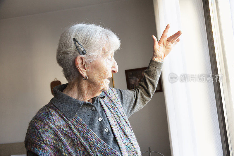 一位年长的女士望着窗外