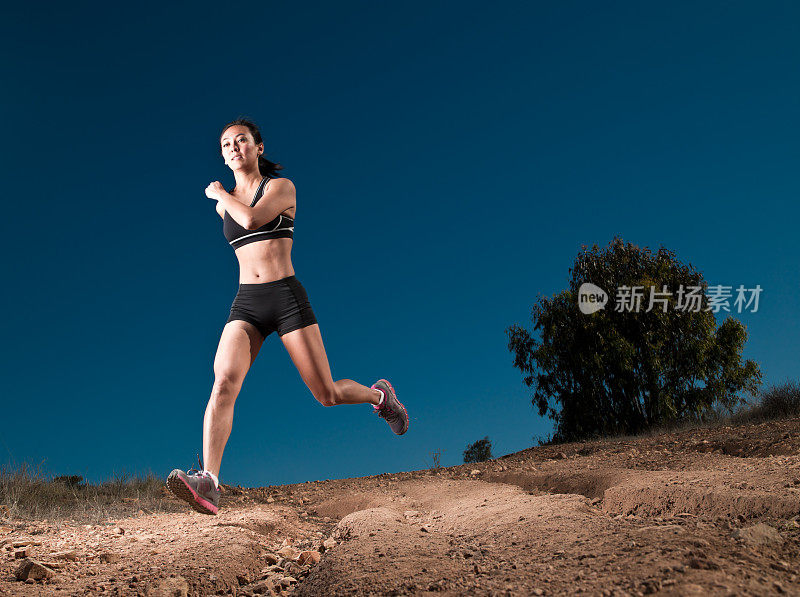 年轻女子在土路上奔跑